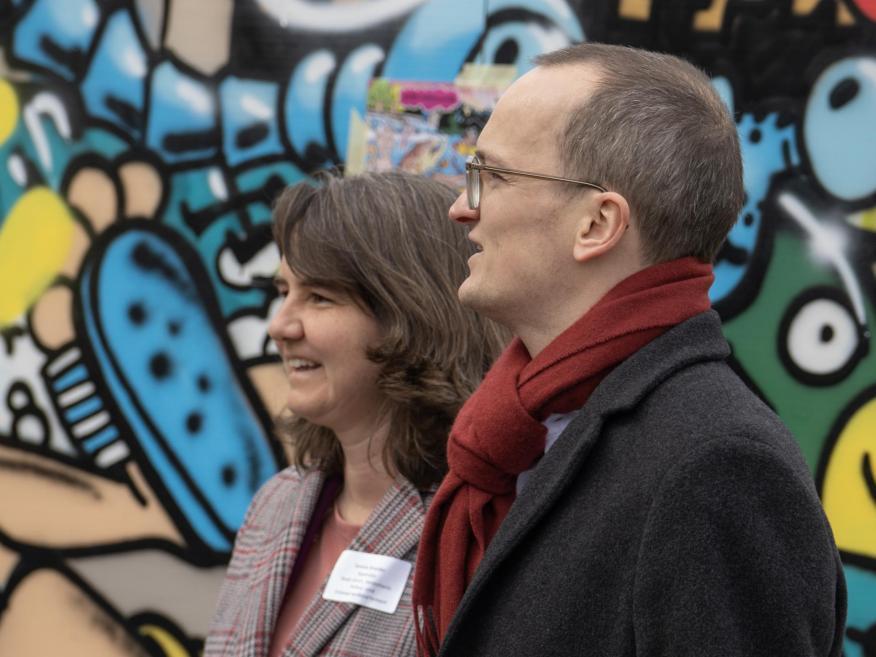 Regierungsrat Martin Neukom und Stadträtin Simone Brander vor einem bunten Graffito.