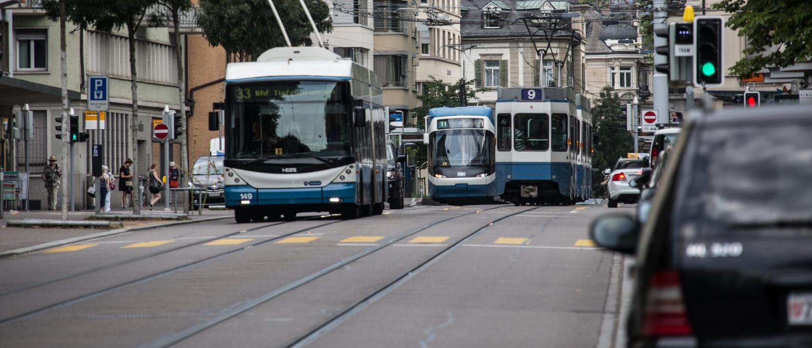 Das Bild zeigt zwei Trams und einen Trolleybus in der Stadt Zürich.