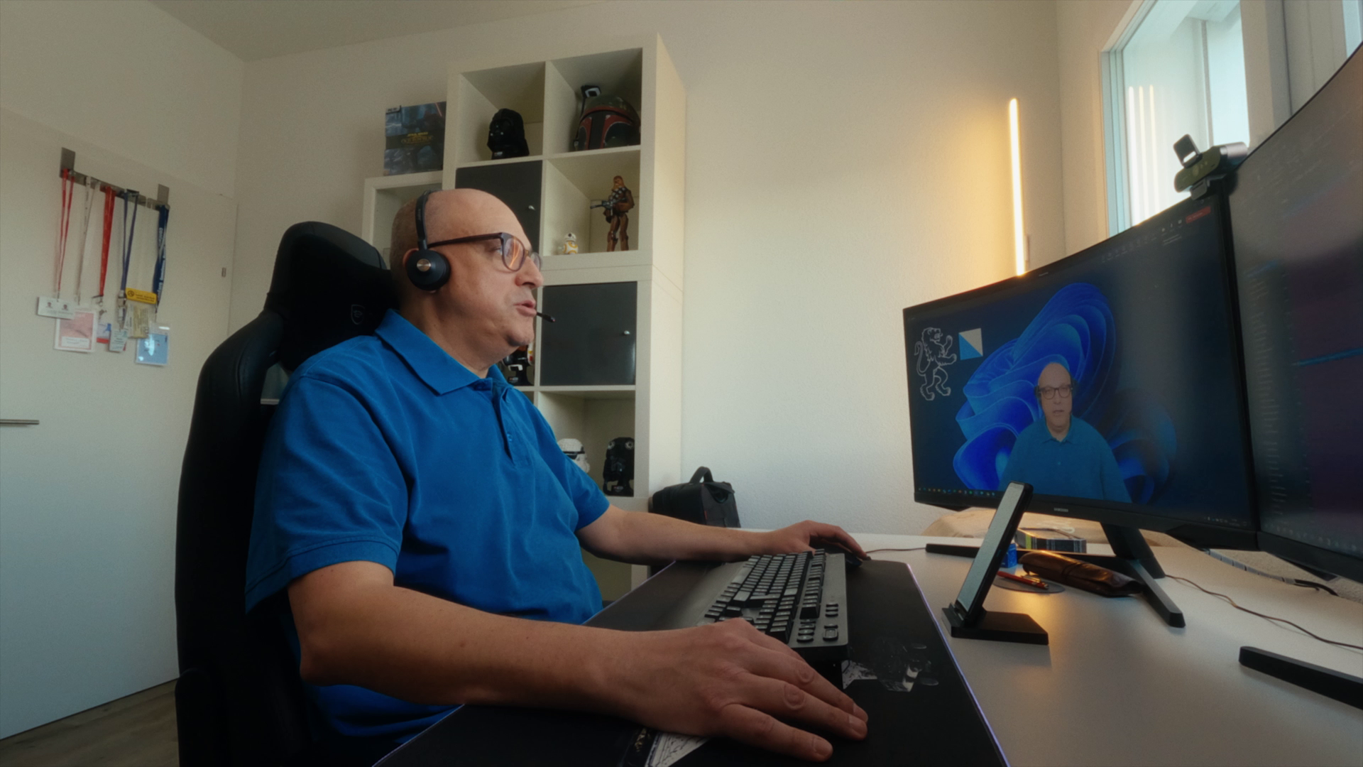 ICT Experte im Home Office vor dem Computer an seinem Schreibtisch führt ein Teamsmeeting mit Kamera durch.