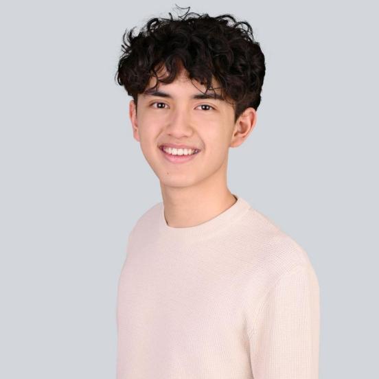 Ein Portraitbild, das unseren Lernenden mit kurzen dunklen Haaren und einem heller Pullover zeigt.