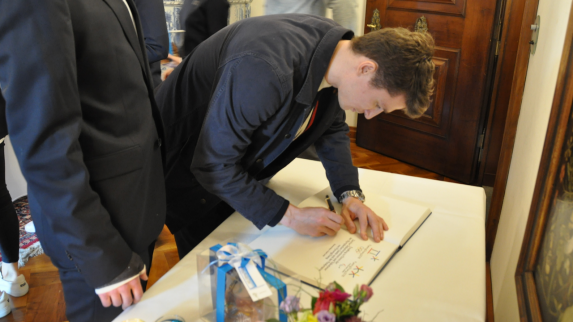 Ein Teilnehmer zum Eintrag ins offizielle Gästebuch des Rathauses.