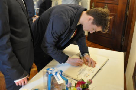Ein Teilnehmer zum Eintrag ins offizielle Gästebuch des Rathauses.