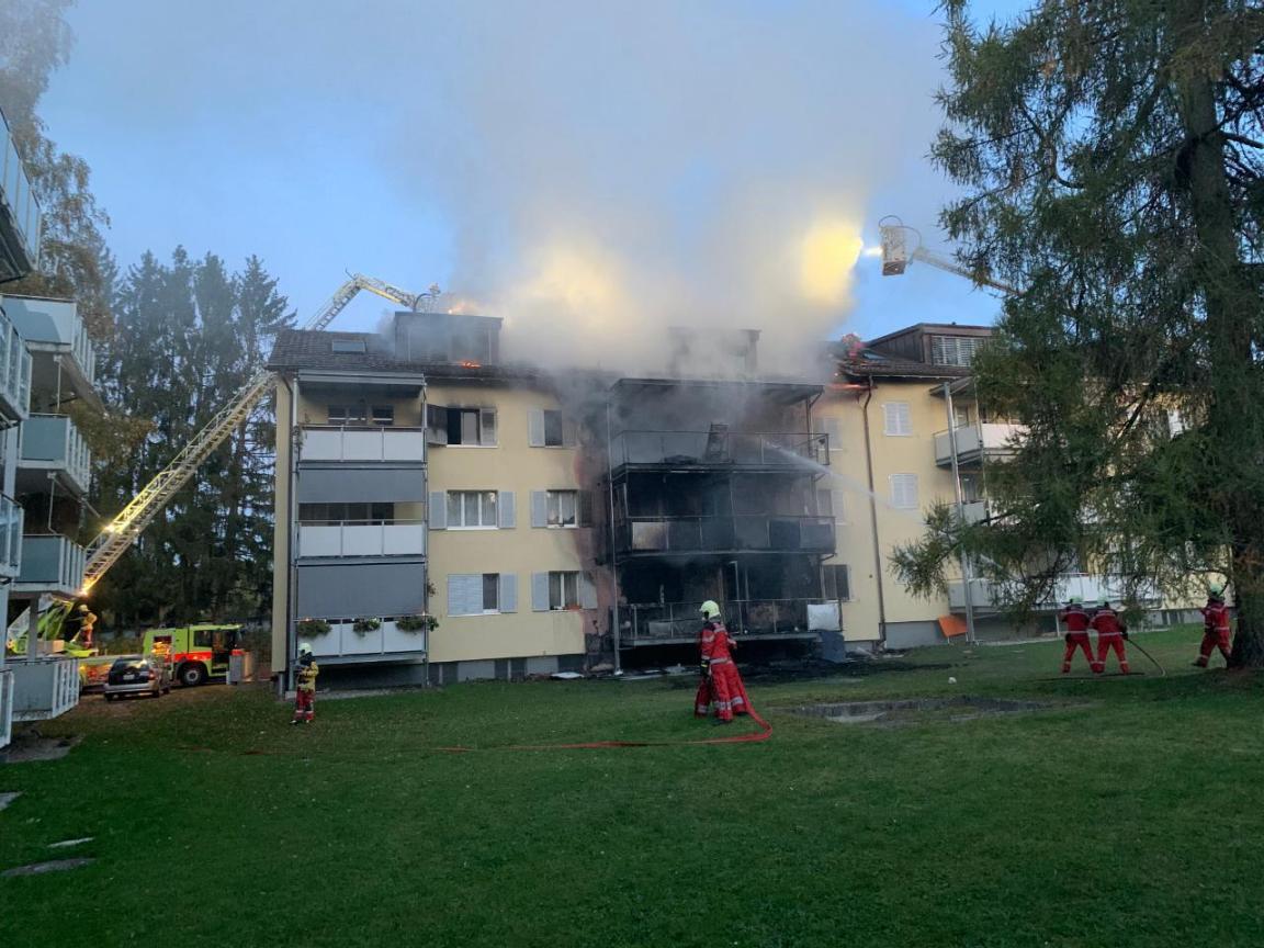 Brandort: Das brennende Haus  und die Feuerwehr bei der Brandbekämpfung.