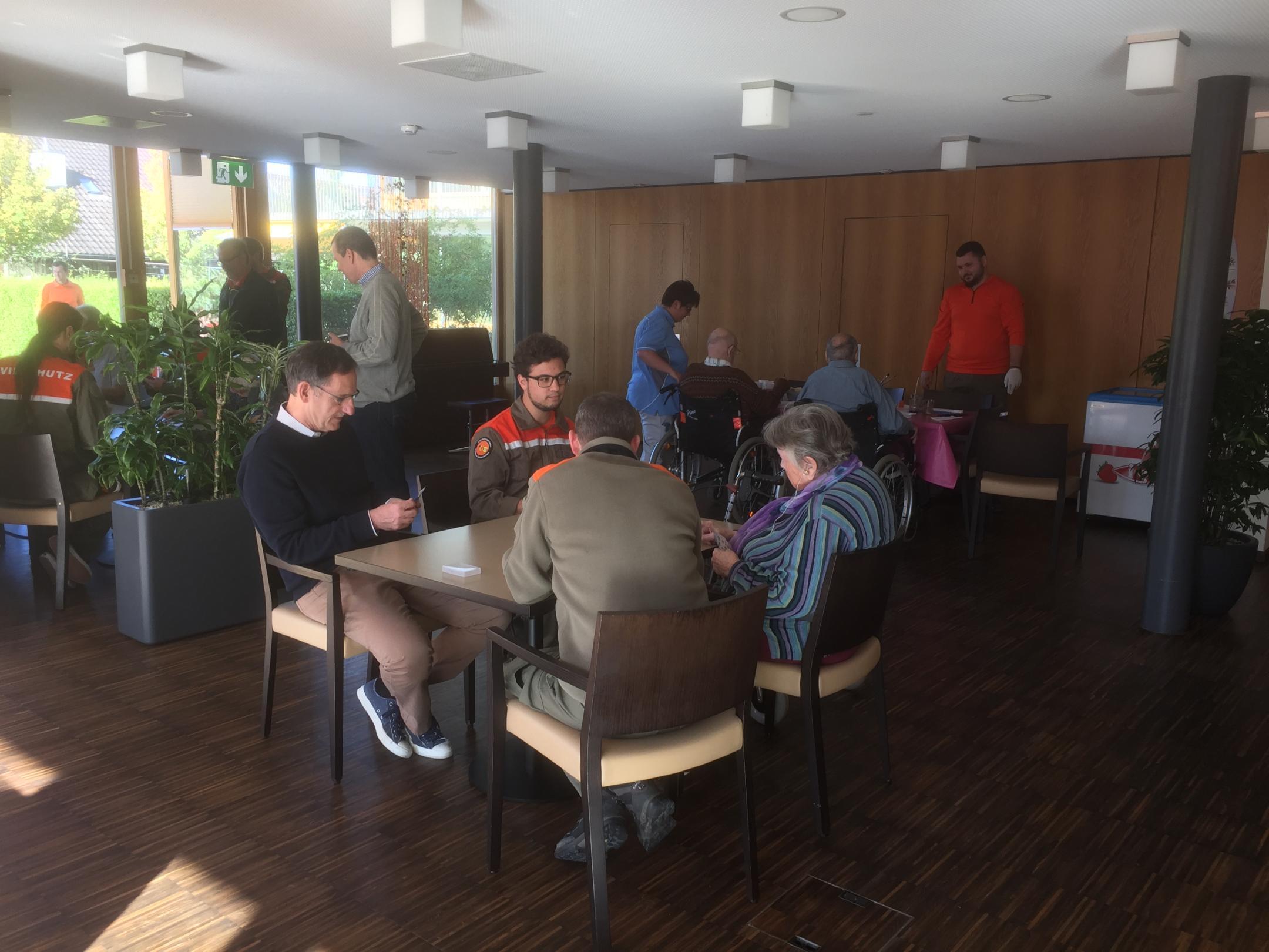 Regierungsrat Mario Fehr beim Jassen mit einer Bewohnerin Alterszentrum Hof in Greifensee und Zivilschutzangehörige der ZSO Greifensee-Schwerzenbach