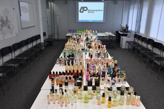 Foto der über 450 gestohlenen Pafums auf mehreren Tischen
