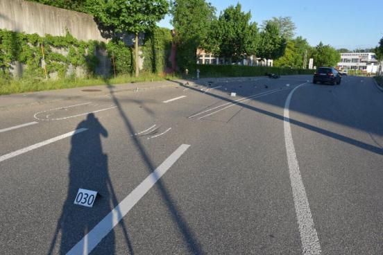 Strasse mit Unfallfahrzeug und vielen Trümmerteilen sowie ein Schatten den Unfallfotographen