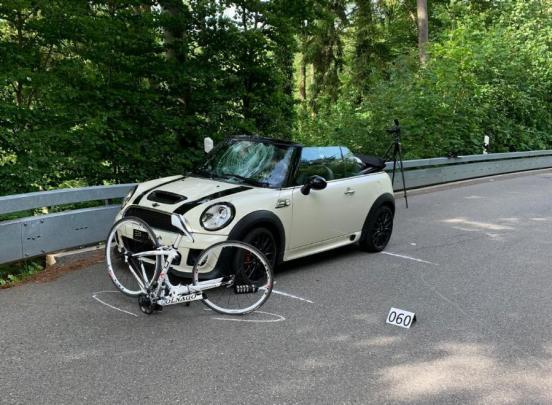 Unfallfahrzeug und Rennvelo stehen auf der Unfallstelle am Strassenrand