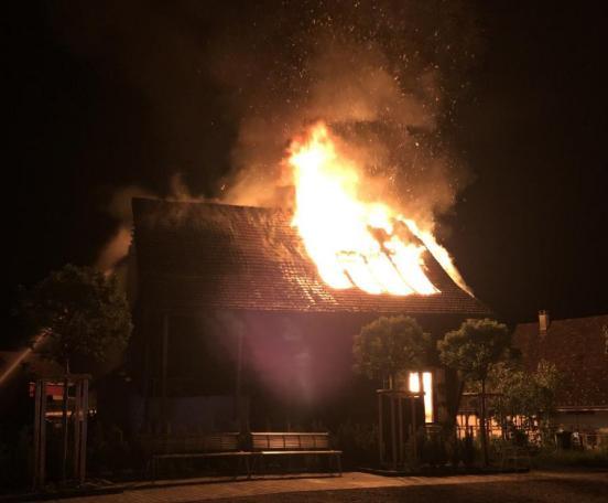 Wohnhaus steht im Vollbrand. Flammen schlagen zum Dach heraus.