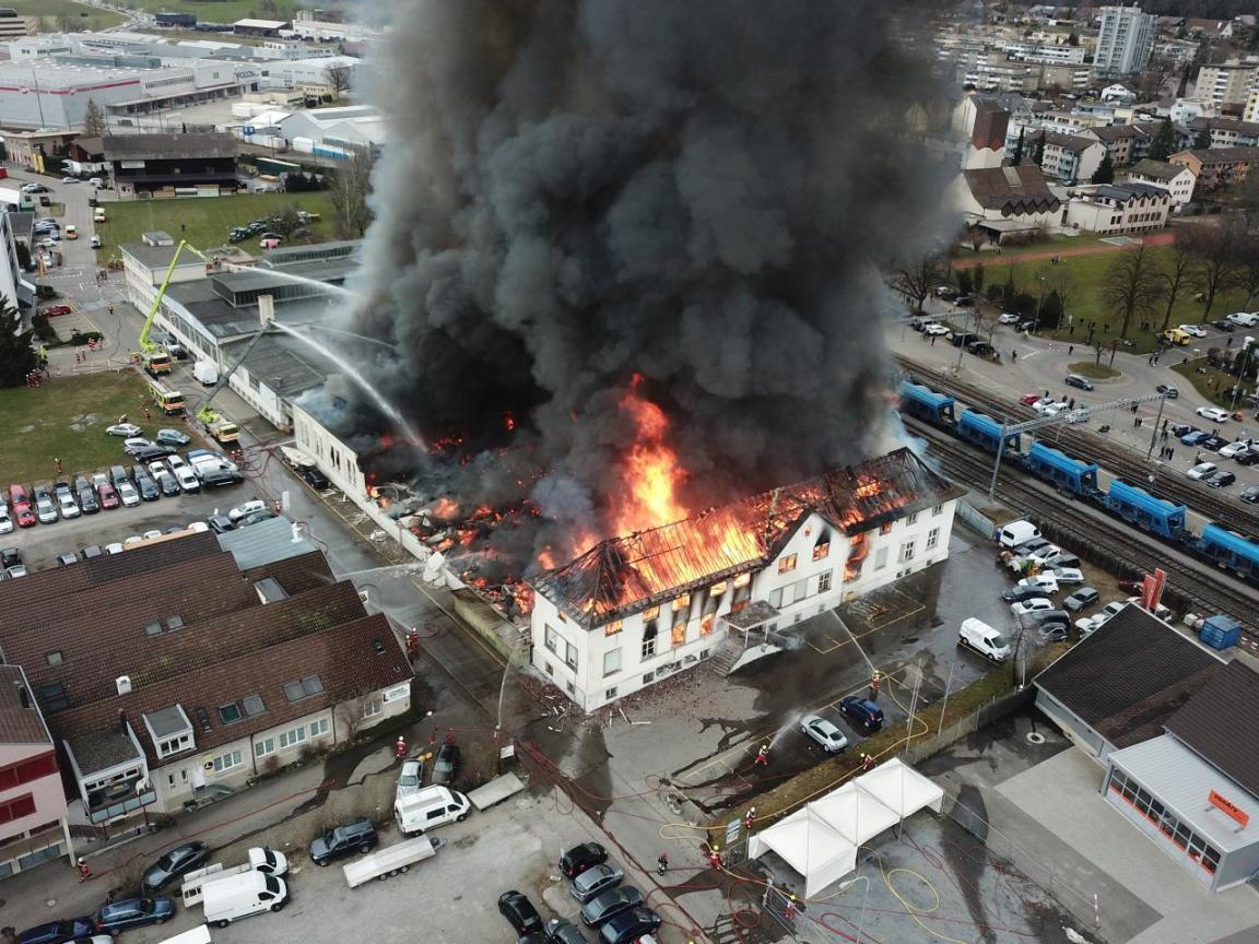 Luftaufnahme des Brandes mit meterhohen Flammen und dichter Rauchsäule