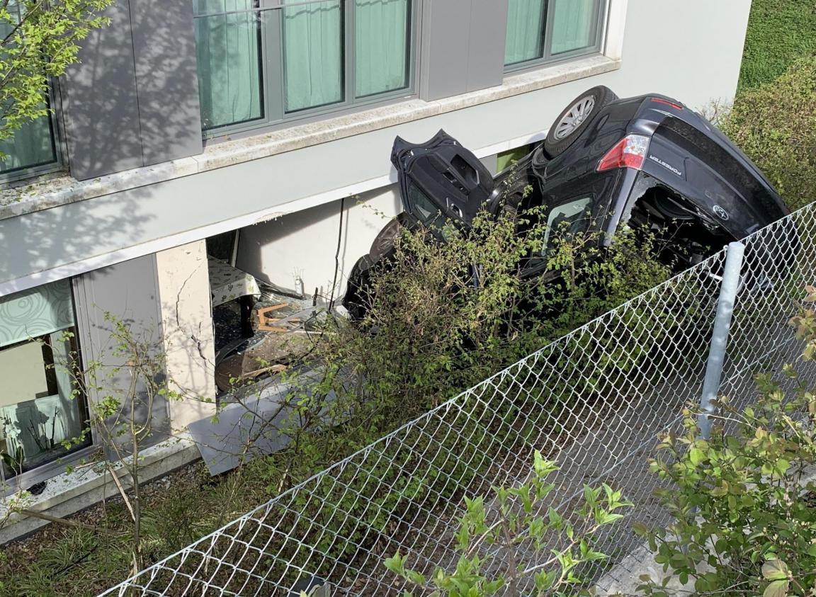 Stark beschädigtes Auto an Böschung sowie beschädigte Hausfassade