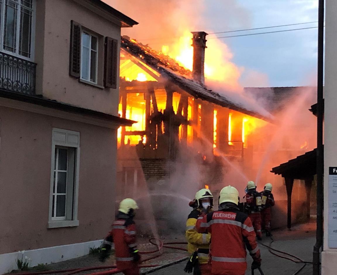 Gebäude in Vollbrand und Feuerwehr bei Löscharbeiten