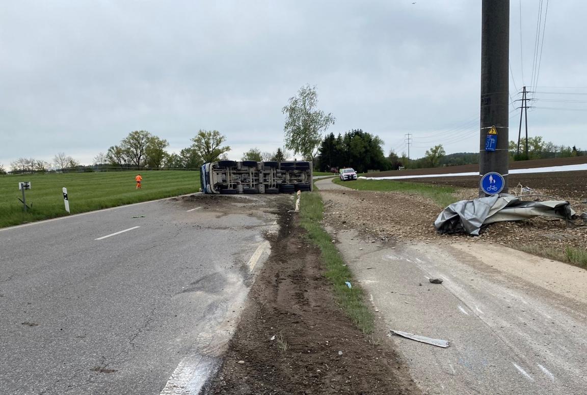 Lastwagen auf der Seite liegend sowie stark verschmutzte Strasse