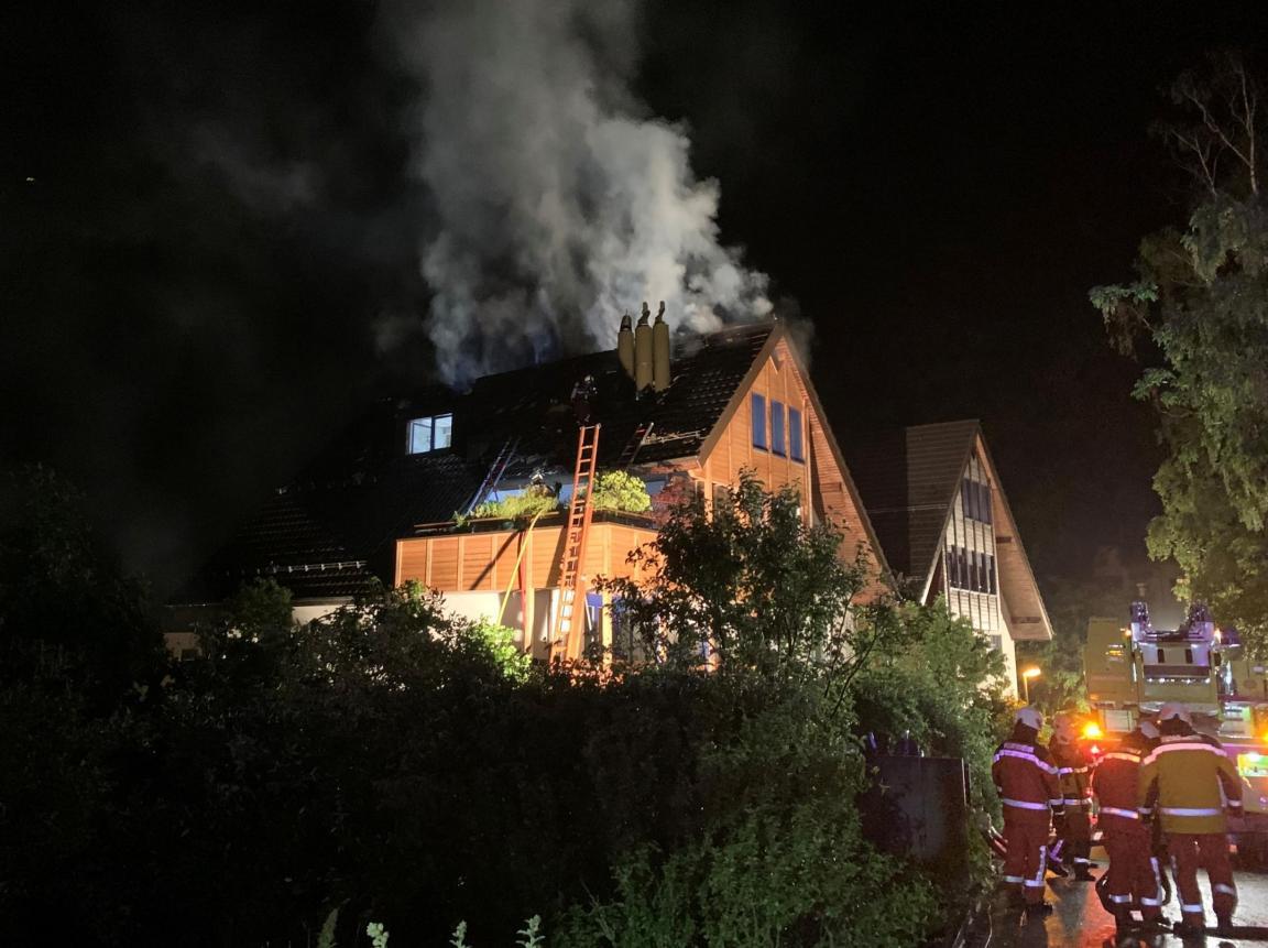 Löscharbeiten bei einem Brand im Dachbereich eines Mehrfamilienhauses