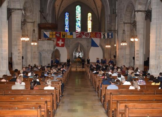 Kirche mit Bezirksfahnen geschmückt und Besuchern in Kirchenbänken