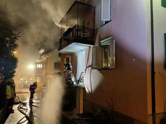 Feuerwehrleute am Bekämpfen des Brandes eines Mehrfamilienhauses