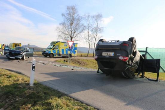 Ein Fahrzeug liegt auf dem Dach, das andere steht beschädigt daneben