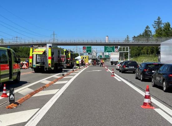 Einsatzfahrzeuge von Feuerwehr und Sanität an der Unfallstelle auf der Autobahn