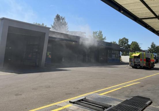 Rauch aus Gewerbehalle und Feuerwehr bei Löscharbeiten