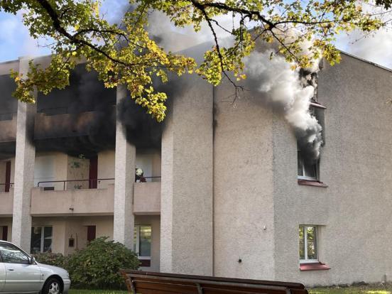 Dichter Rauch qualmt aus einer Wohnung in einem Mehrfamilienhaus