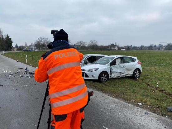 Polizist macht Fotoaufnahmen von den beschädigten Fahrzeugen auf der Unfallstelle