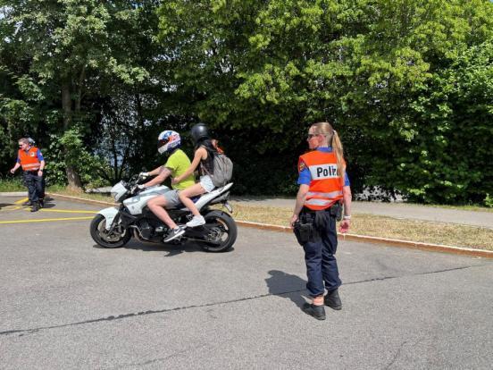 Motorrad mit zwei Personen in Sommerkleidung in einer Polizeikontrolle