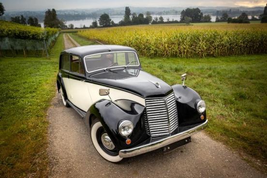 Schwarz-weisses Oldtimerfahrzeug auf einem Feldweg