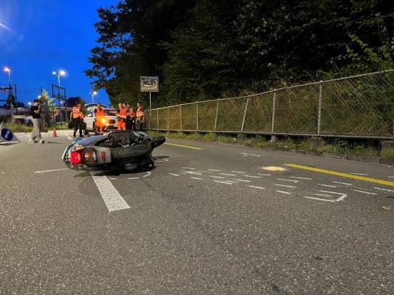 Der verunfallte Motorroller liegt auf der Fahrbahn