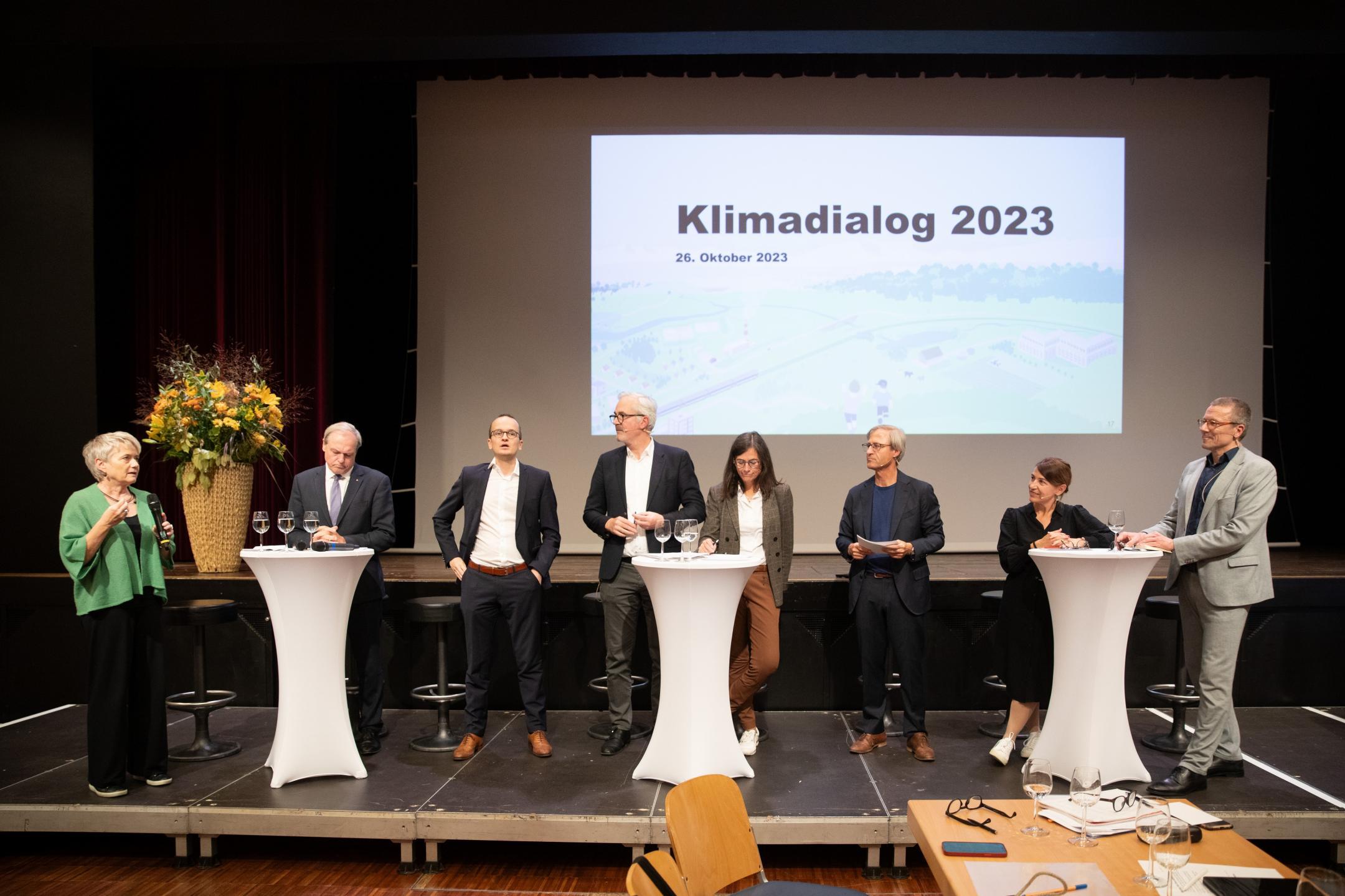 Die Gastgebenden und die Podiumsteilnehmenden diskutieren auf der Bühne.