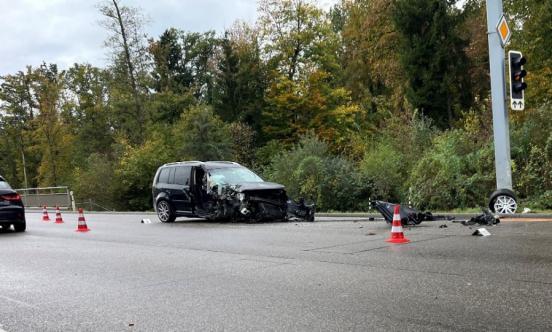 Das völlig demolierte Auto steht entgegen der Fahrtrichtung auf der Strasse. Es liegen viele Trümmerteile auf der Strasse.
