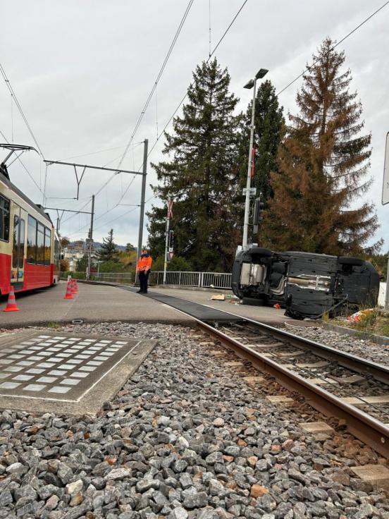 Auto liegt neben Zuggleisen auf der Seite