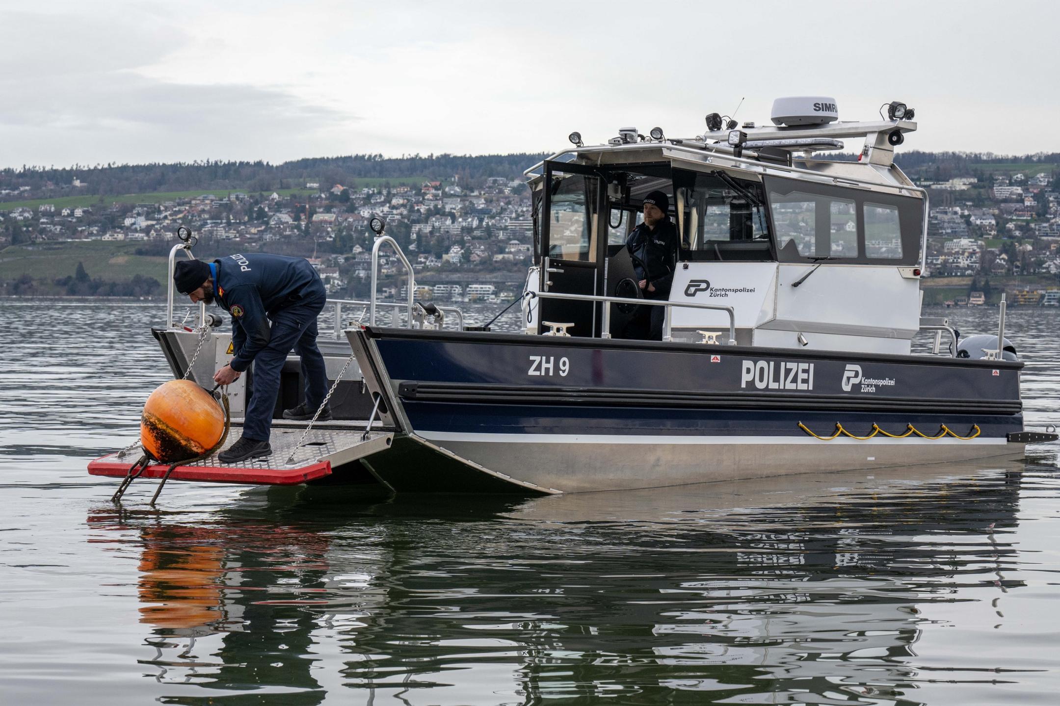 Das Einsatzschiff hat die Bugklappe geöffnet und ein Seepolizei hantiert an einer Boje