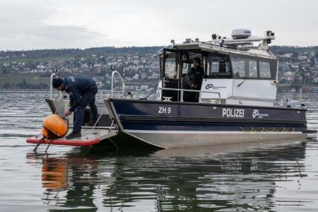 Das Einsatzschiff hat die Bugklappe geöffnet und ein Seepolizei hantiert an einer Boje