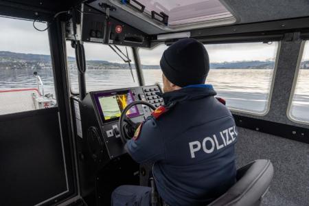 Ein Seepolizist am Führerstand in der geschlossenen Kabine des Schiffs