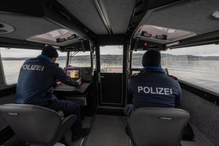 Zwei Seepolizisten sitzen im geschlossenen Schiffs-Führerstand und fahren auf dem Zürichsee