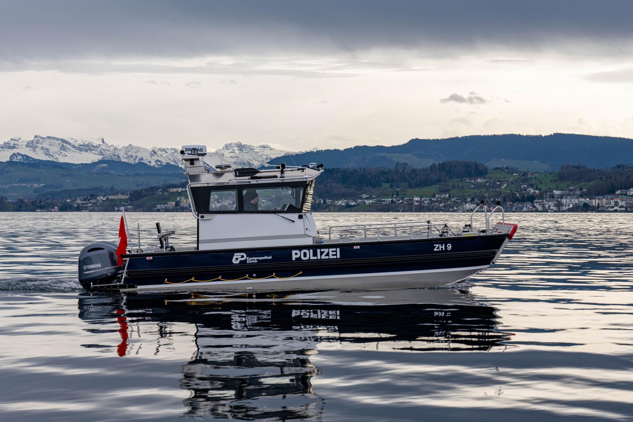 Das Schiff fährt langsam auf dem Zürichsee. Auf der Seite ist es mit Polizei beschriftet und trägt das Logo der Kantonspolizei Zürich
