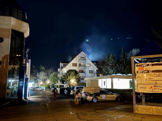 Ein Mehrfamilienhaus aus dessen oberem Stockwerk Rauch dringt