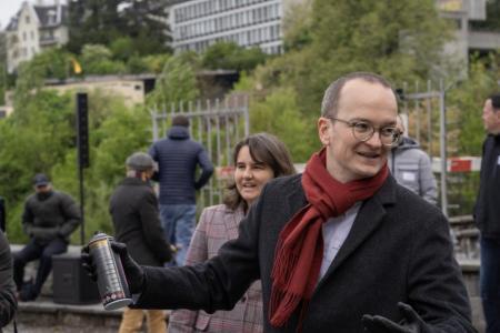 Regierungsrat Martin Neukom am Platzspitz mit Spraydose in der Hand. Im Hintergrund Journalisten und Gäste.