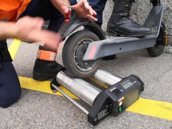 Hinterrad eines E-Trottinetts auf einer Geschwindigkeits-Messrolle