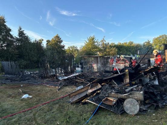 Feuerwehrleute arbeiten in einer Brandruinen