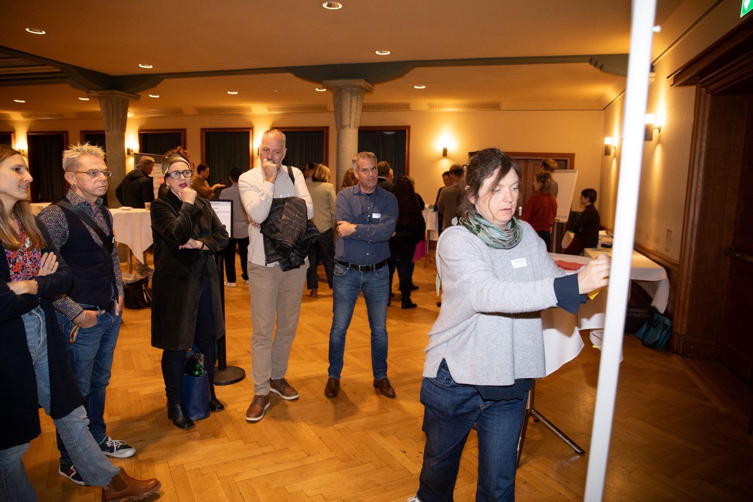 Mehrer Personen hören den Ausführungen der Arbeitsgruppe zu.