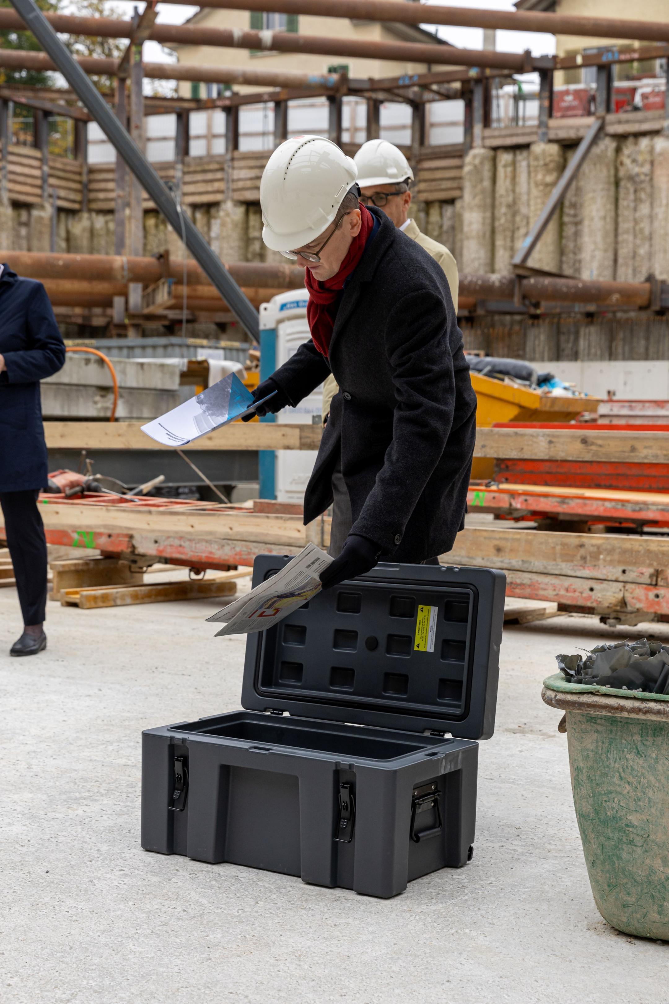 Baudirektor Martin Neukom befüllt eine Zeitkapsel.