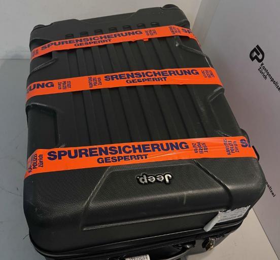 Sichergestellter Koffer mit orangem Klebeband umwickelt