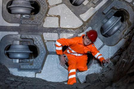 Regierungsrat Martin Neukom steigt durch das Mannsloch im Bohrkopf der Tunnelbohrmaschine.