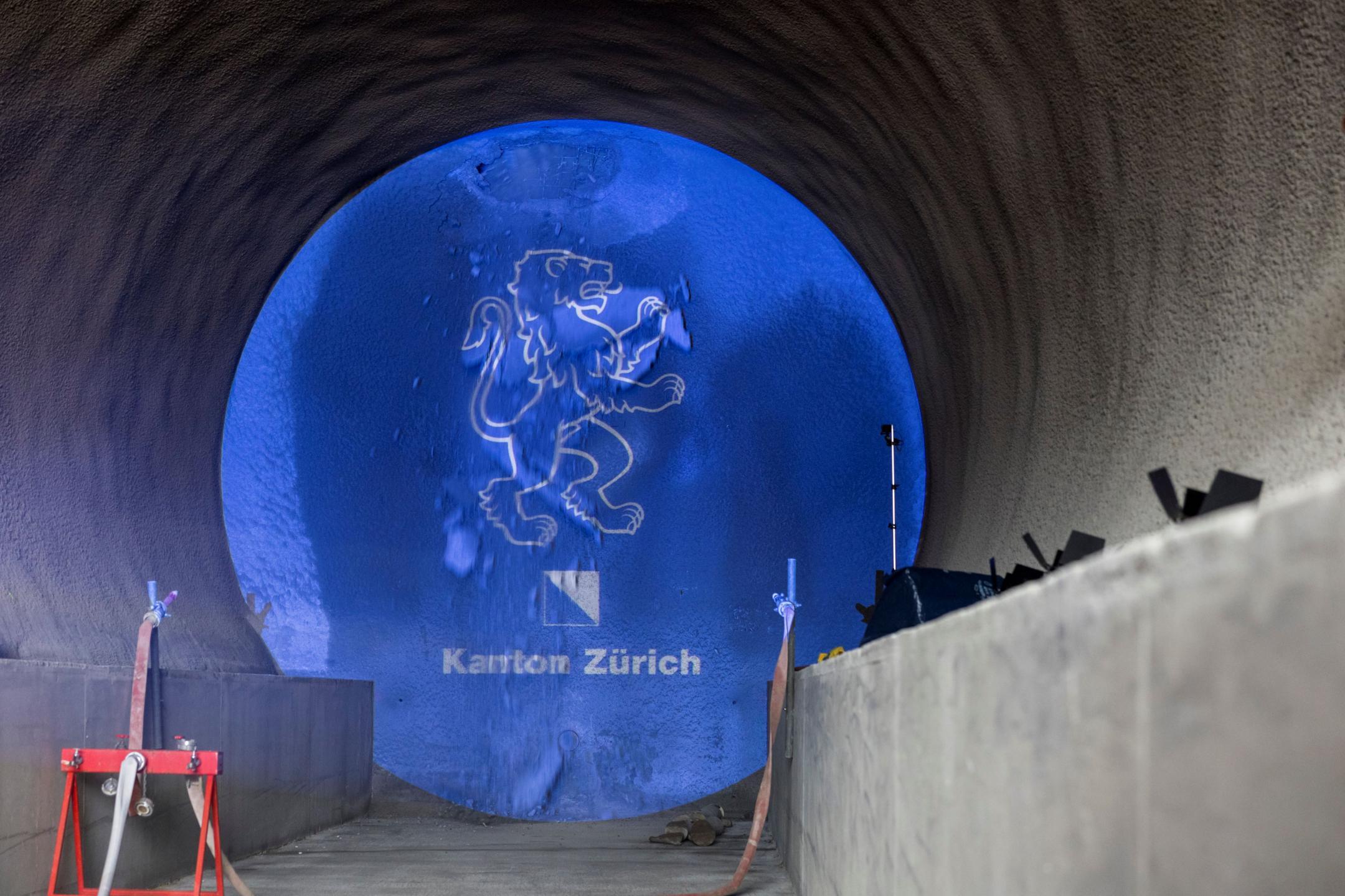 Der Bohrkopf frisst sich durch die Tunnelwand, erste Schneidräder werden sichtbar.