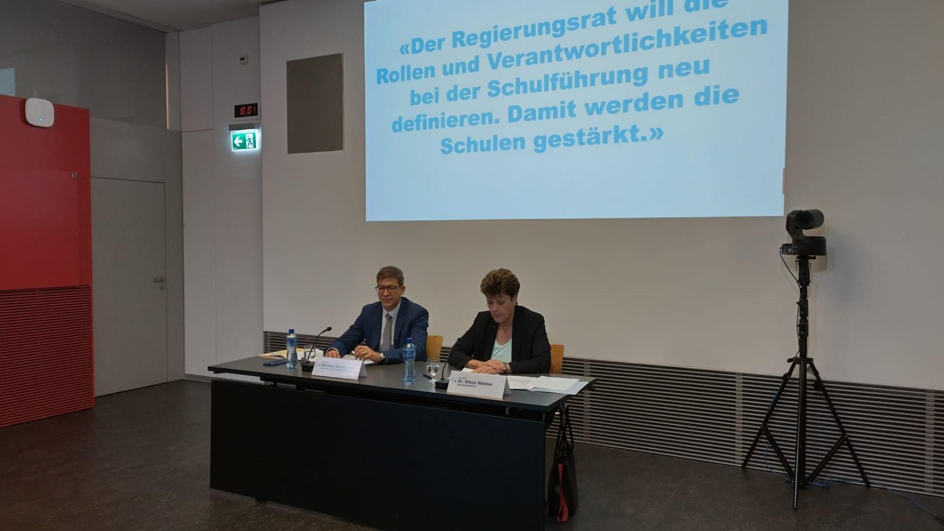 Zwei Personen sitzen an einem Tisch.