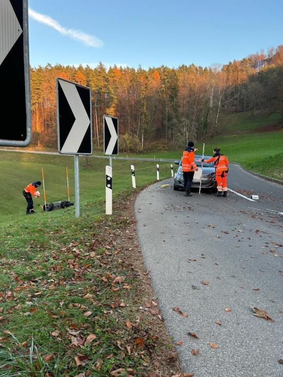 Unfallfahrzeug steht auf der Strasse und Polizisten sichern Spuren