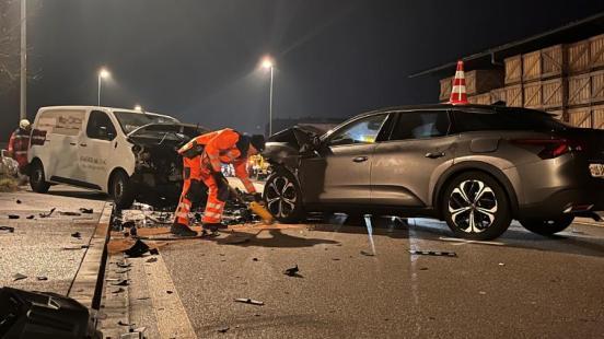 Ein Polizist zeichnet Spuren vor den Unfallfahrzeugen ein