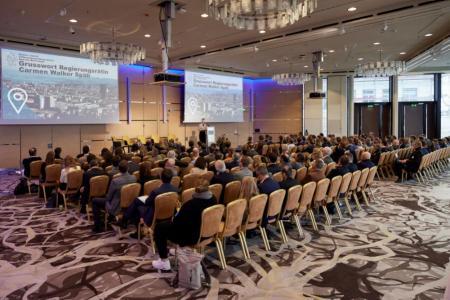 Volkswirtschaftsdirektorin Carmen Walker Späh steht auf der Bühne in einem grossen Saal und spricht zu 150 Menschen, die im Saal sitzen.