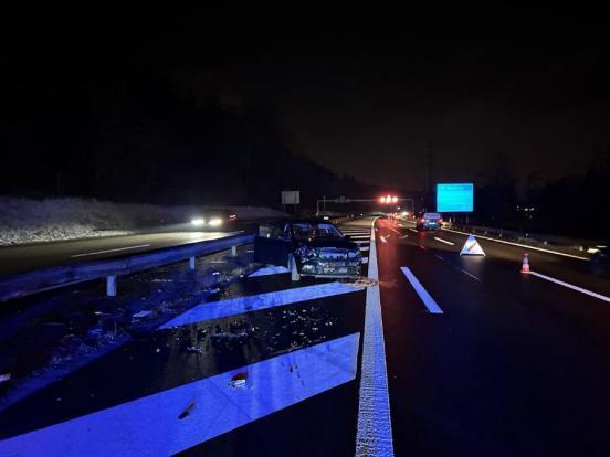 Unfallfahrzeug steht in der Nacht auf einer Sperrfläche der Autobahn A3