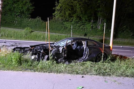 Ein schwarzes, linksseitig total beschädigtes Auto